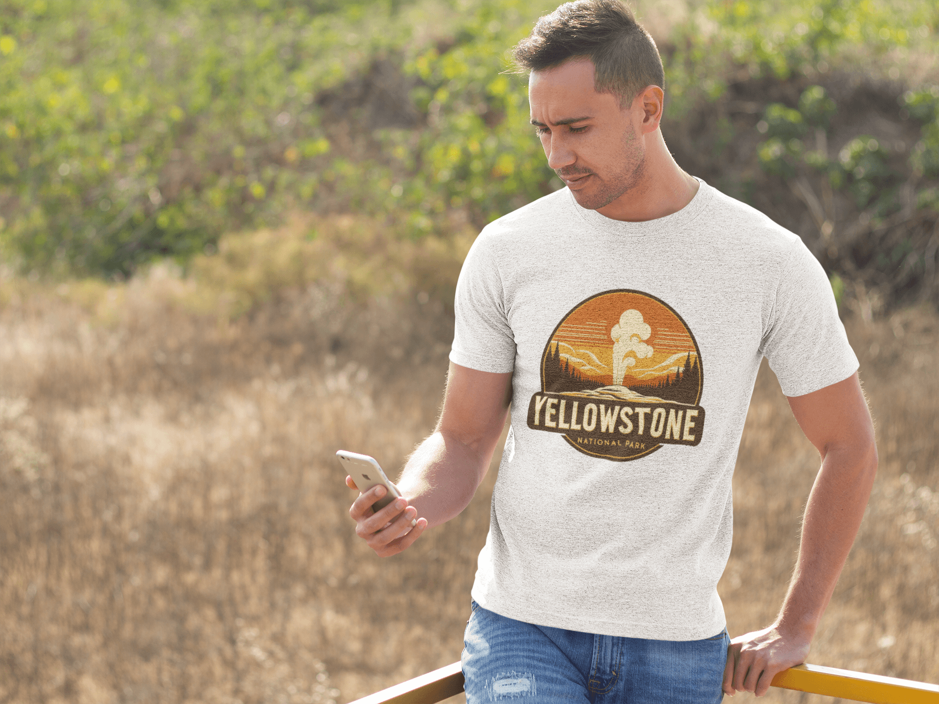 White Yellowstone National Park tee from Wyld Peak worn by man at scenic Yellowstone lookout.