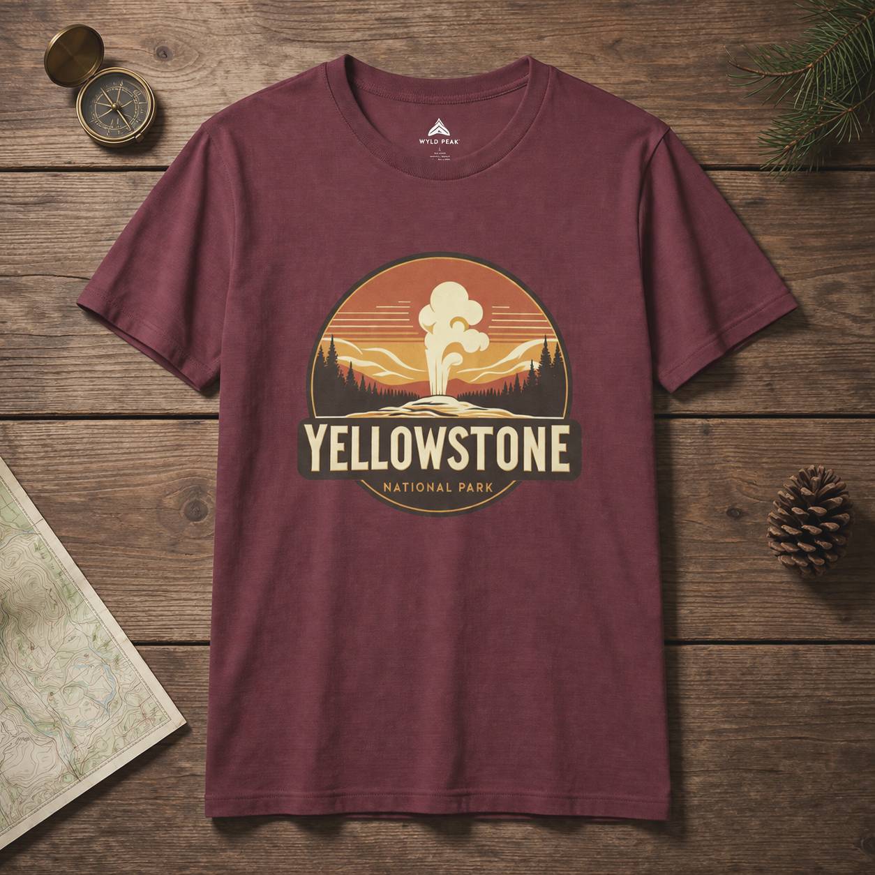 Maroon t-shirt with Yellowstone National Park graphic on a wooden surface