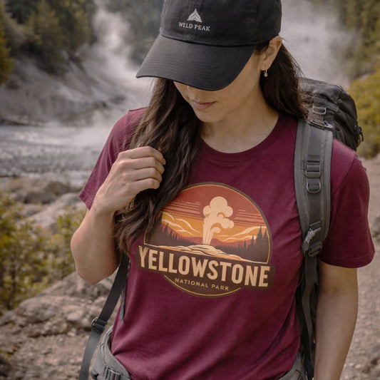 Person wearing a maroon Yellowstone National Park t-shirt with a backpack in a natural setting.