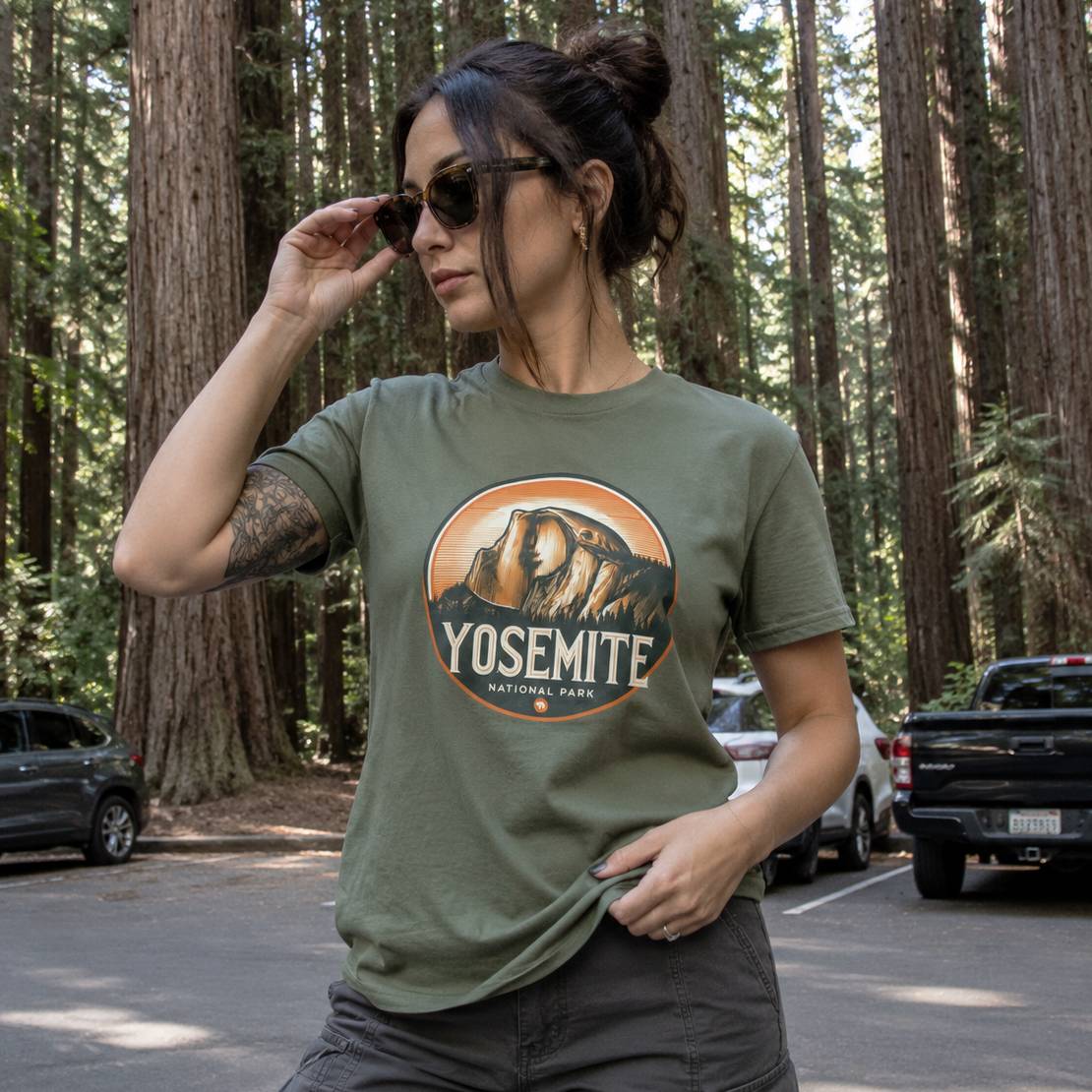 Woman wearing a green Yosemite National Park t-shirt in a forest setting.