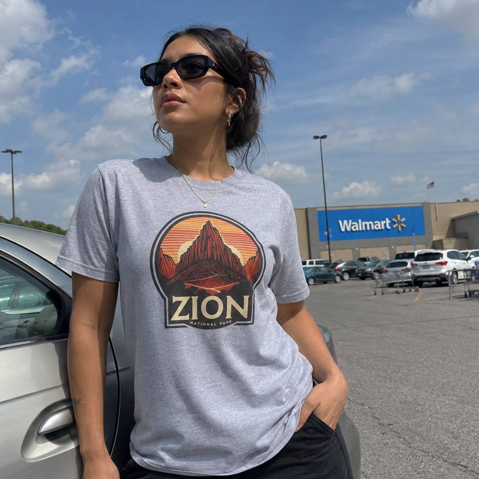 Person wearing a t-shirt with Zion National Park design in a Walmart parking lot.
