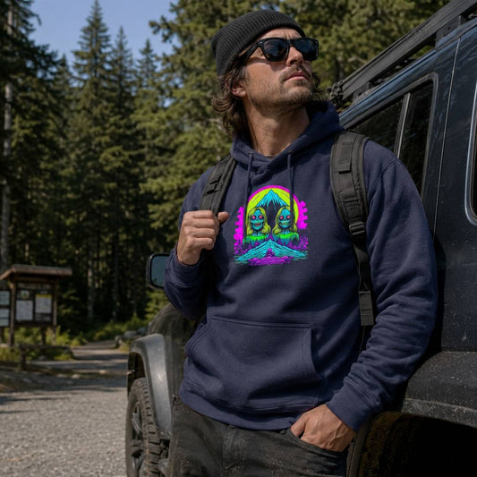 Man wearing a navy hoodie with a colorful graphic, standing next to a vehicle in a forest setting.