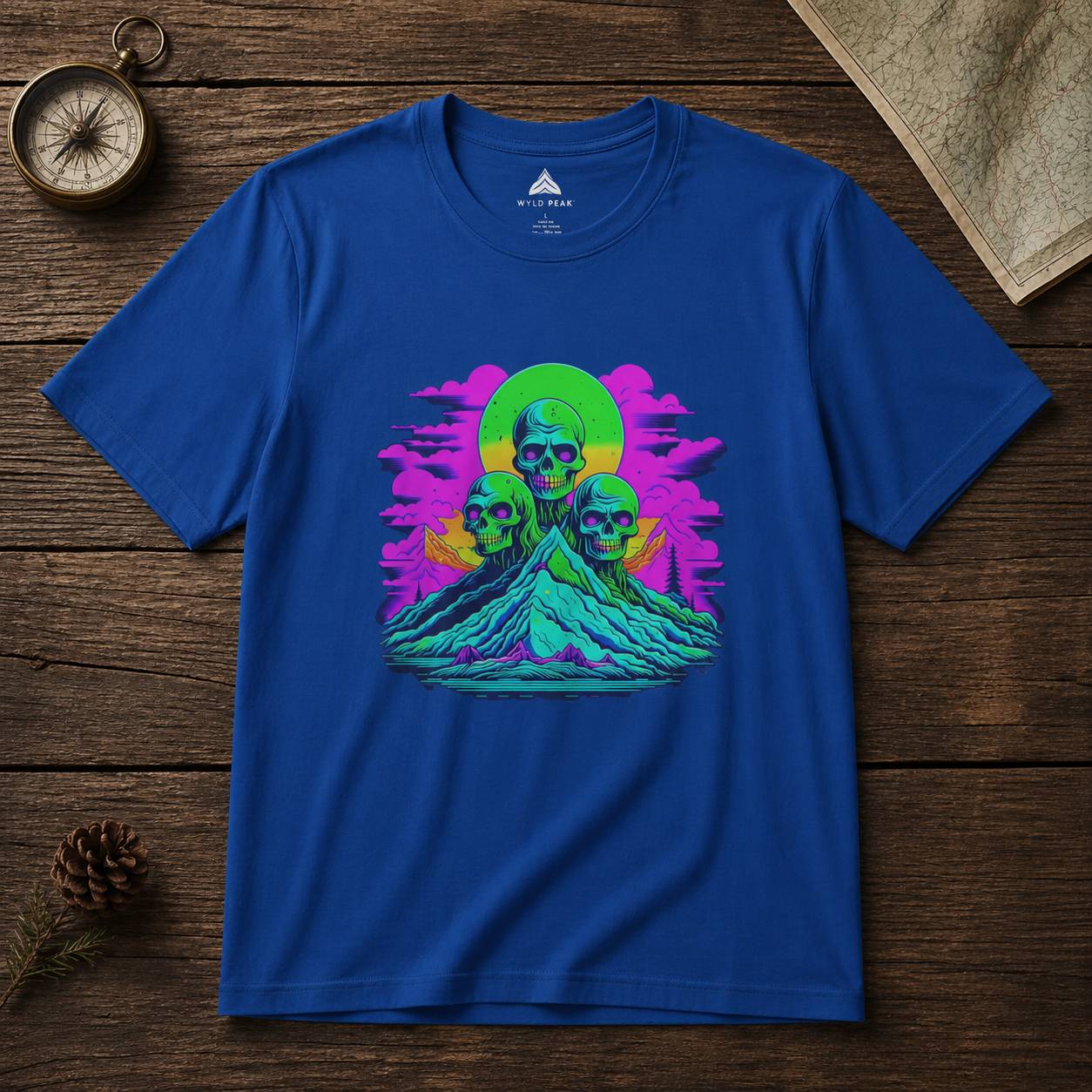 Blue t-shirt with a colorful graphic design of skulls and a rainbow circle on a wooden surface.