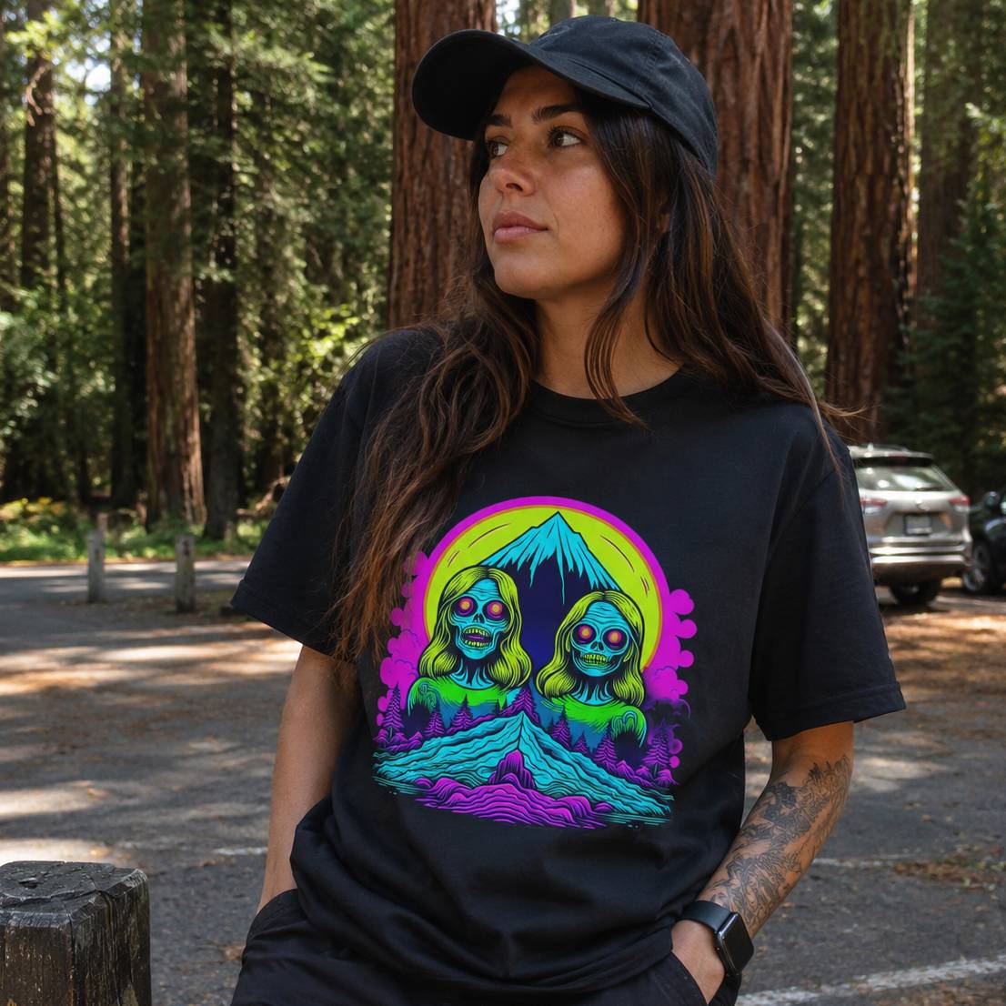 Person wearing a black t-shirt with a colorful graphic in a forest setting