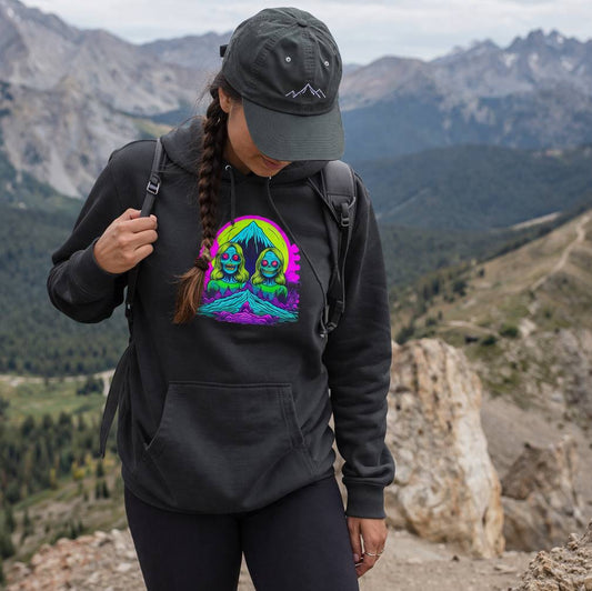 Person wearing a black hoodie with a colorful graphic design in a mountainous landscape