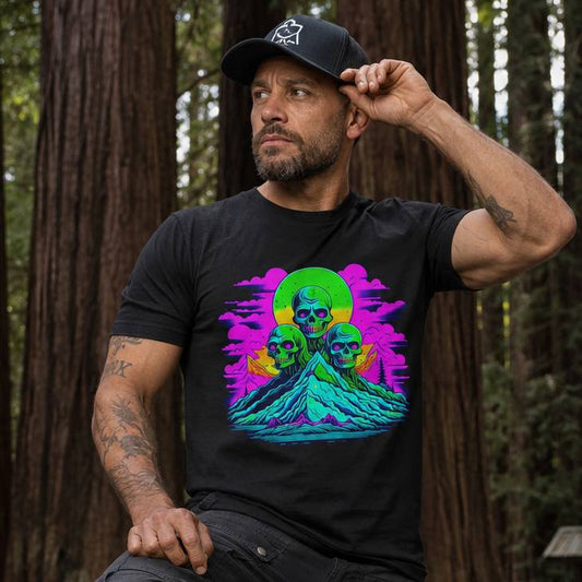 Man wearing a black t-shirt with colorful graphic design in a forest setting