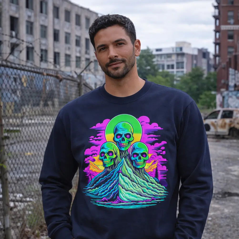 Man wearing a dark blue sweatshirt with a colorful graphic design of skulls and flames in an urban setting.